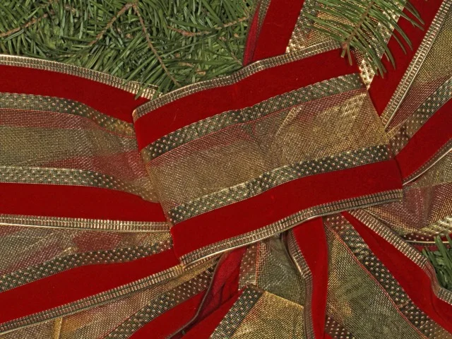 Ünnepi szalagdíszítés fenyőágas koszorún közelről